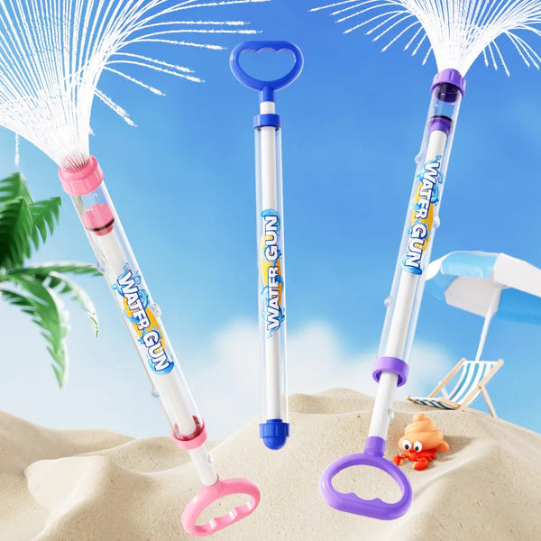 Bunte Wasserpistolen und Blaster vor blauem Himmel und Sand