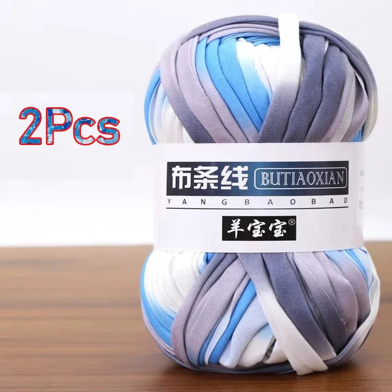 A skein of soft chunky t-shirt yarn in various shades of blue, gray, and white, packaged as a 2-pack.