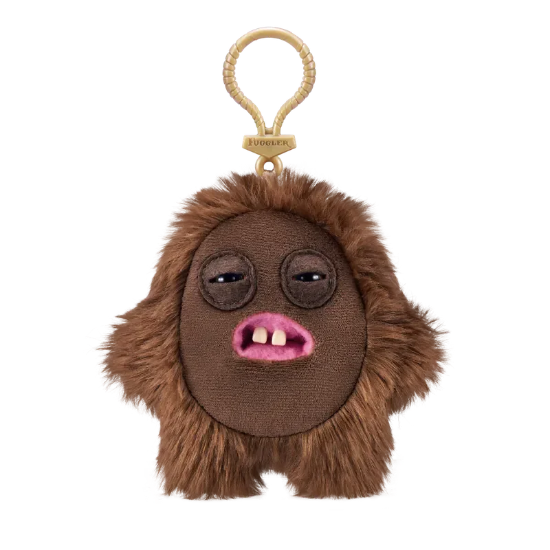 A brown plush monster with large eyes and pink mouth attached to a gold-colored keychain.