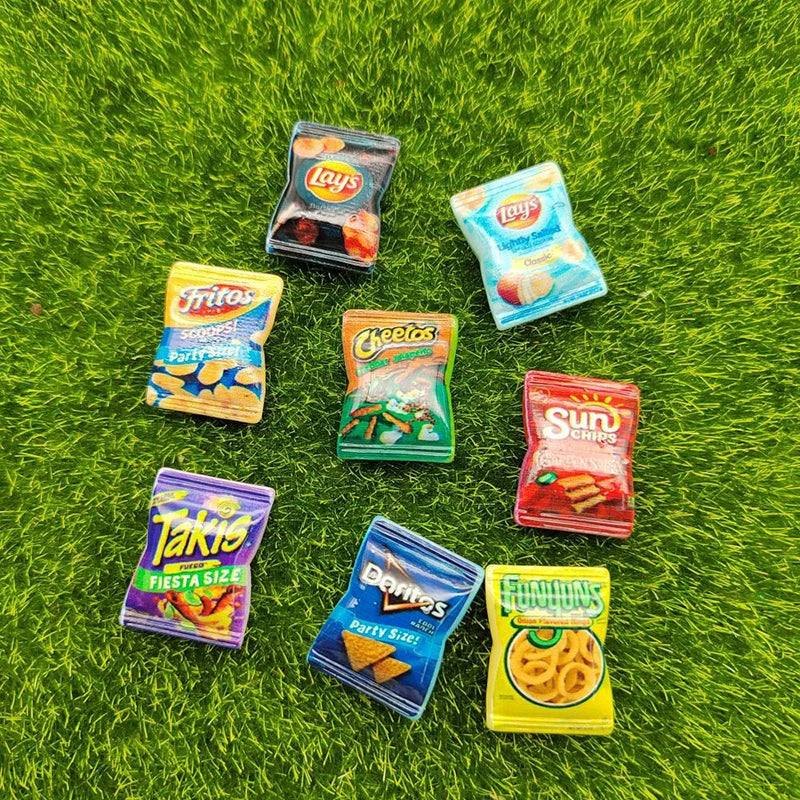 A collection of ten colorful potato chip snacks from various brands like Lay's, Fritos, Cheetos, and Takis arranged on green 