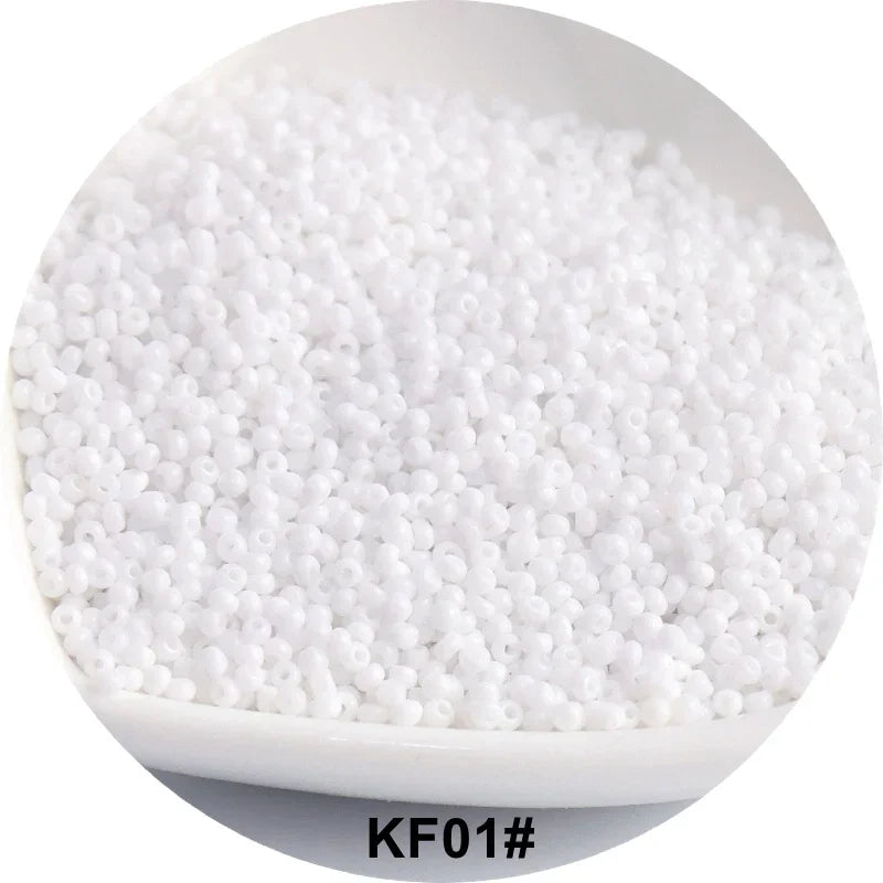 A white bowl filled with small, round, solid glass seed beads for jewelry and craft.