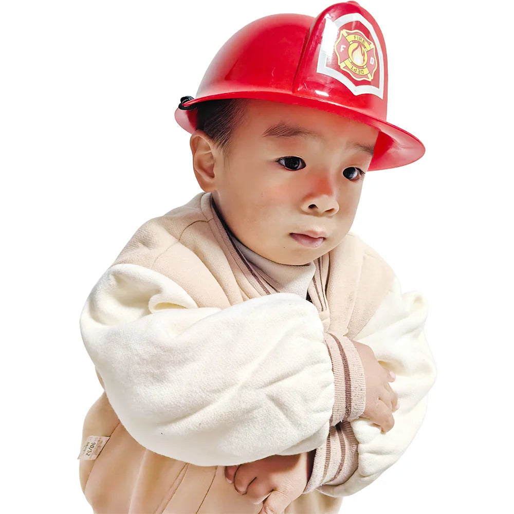 A young child wearing a red firefighter helmet and a beige jacket.
