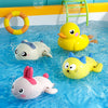 A collection of colorful bath toys including a yellow duck, a white elephant, and a pink rabbit floating in blue water.