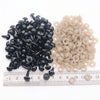 A collection of black and beige plastic safety eyes for amigurumi with locking washers displayed on a ruler.