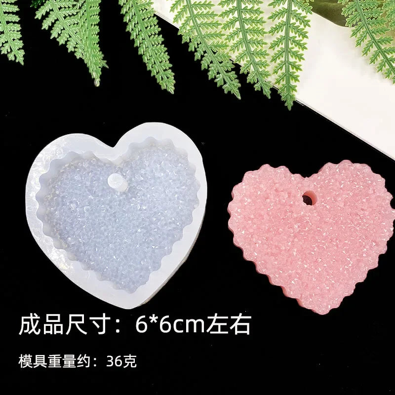 A set of flexible silicone resin molds in heart shapes, pink and clear/white, displayed against a dark background.