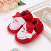 A pair of red felt shoes shaped like Santa Claus with white trim and a butterfly cutout on a white background.