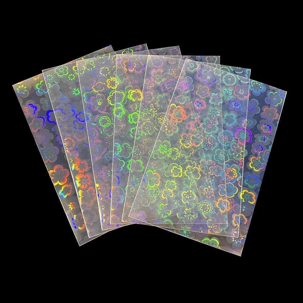 A stack of holographic card sleeves showing iridescent colors and floral patterns.