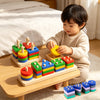 A toddler is playing with a wooden geometric shape sorter puzzle featuring colorful blocks.