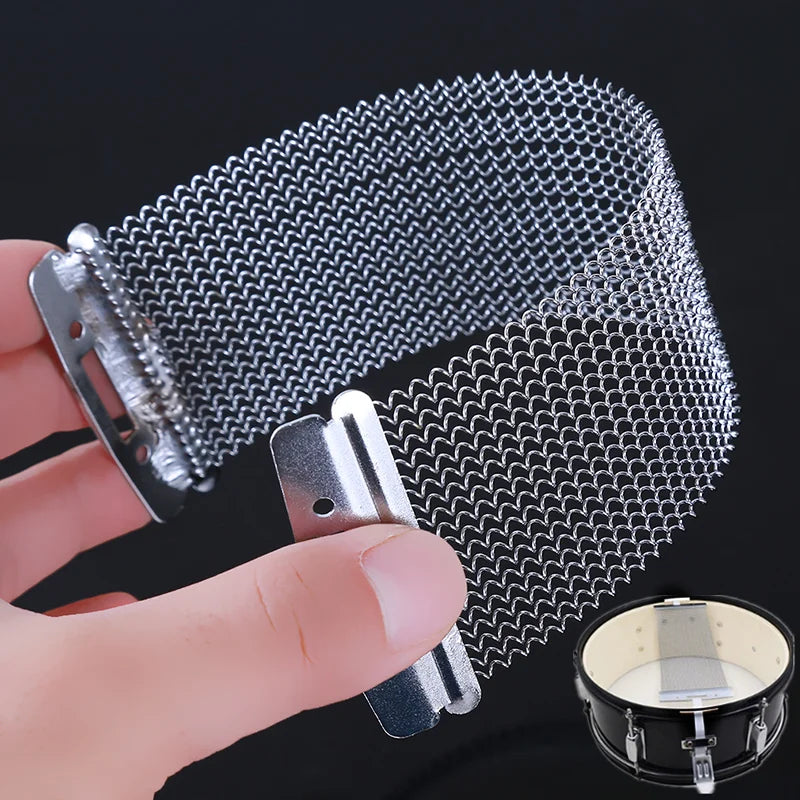A hand holds a snare drum wire strand, showing the fine metal wires used for cajon and snare drums.