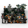 A detailed miniature diorama of a haunted house built from gray and green building blocks featuring pumpkins and spooky folia