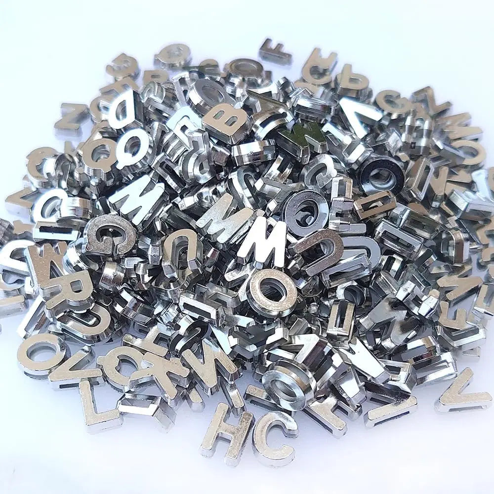 A pile of silver acrylic alphabet letter beads for jewelry making and crafts