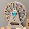 A wooden rainbow acrylic building block wheel with various colored gems and clear blocks.