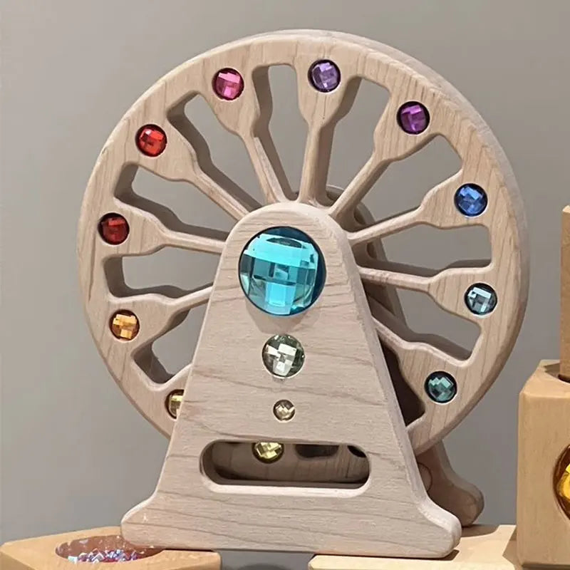 A wooden rainbow acrylic building block wheel with various colored gems and clear blocks.