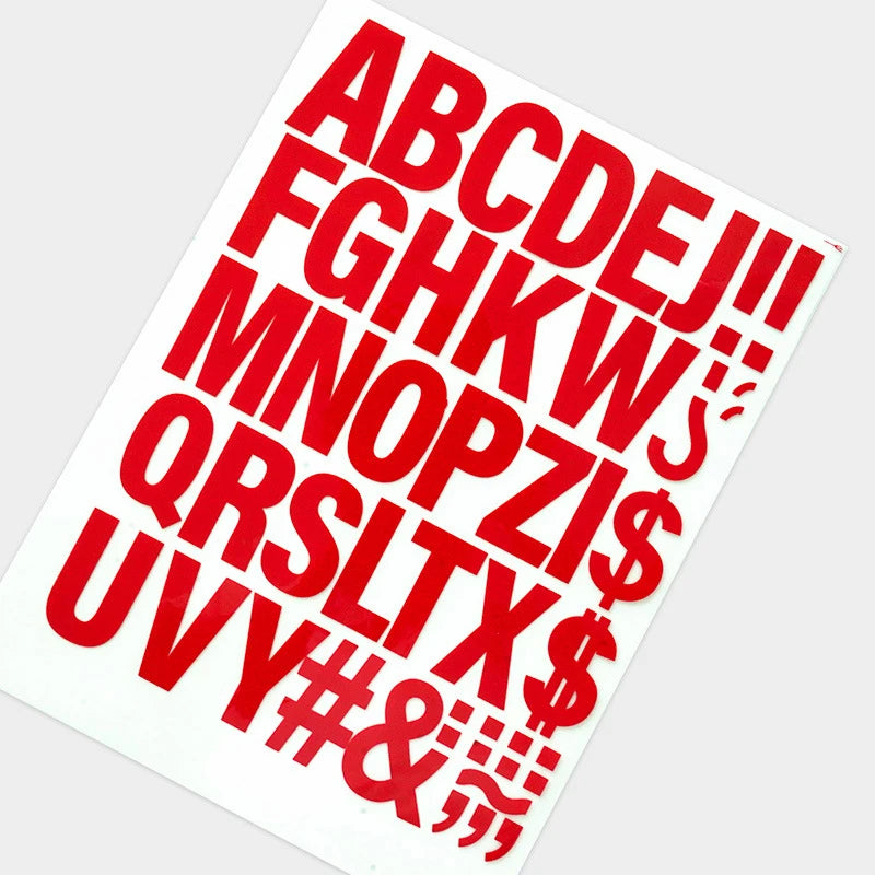 A sheet of red lettering spelling out the alphabet and symbols for DIY iron-on heat transfer patches.