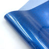 Close-up of a blue glitter holographic heat transfer vinyl sheet rolled up.
