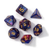 A collection of seven polyhedral acrylic dice in various colors and shapes scattered on a white surface.