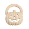 A light beige silicone pumpkin baby teether with a textured rim and carved facial features.