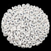 A pile of small white acrylic alphabet letter beads for jewelry making