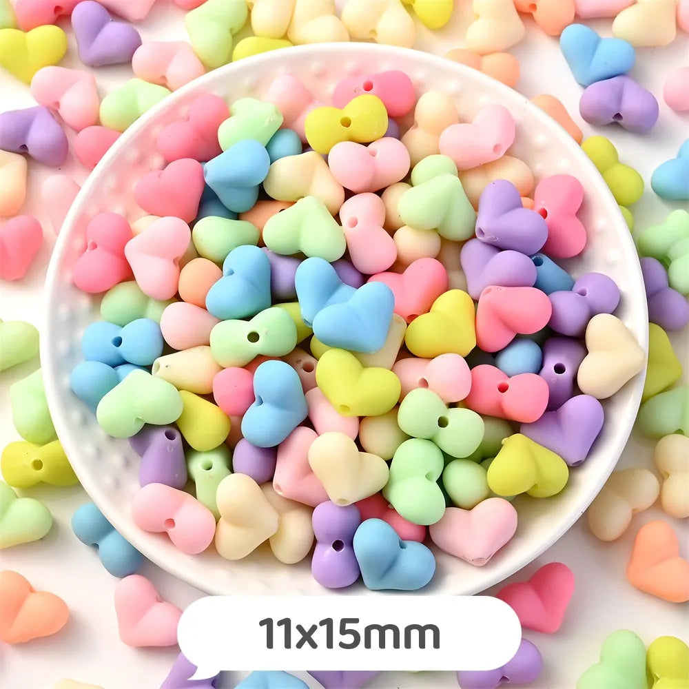 A bowl filled with pastel bear-shaped acrylic craft beads in various shades of pink, yellow, blue, and purple.