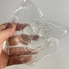 A hand holds a clear plastic silicone cat claw squeeze toy with multiple pads for stress relief and fidgeting.