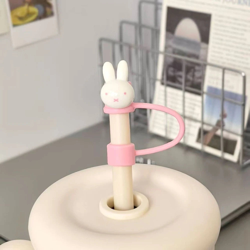 A pink Miffy rabbit straw topper with a handle and base sits on a light-colored surface.