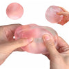 Hands hold a pink mochi squishy stress relief toy, showing its texture and size.