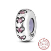 A silver heart charm bead with pink stones is shown against a white background.