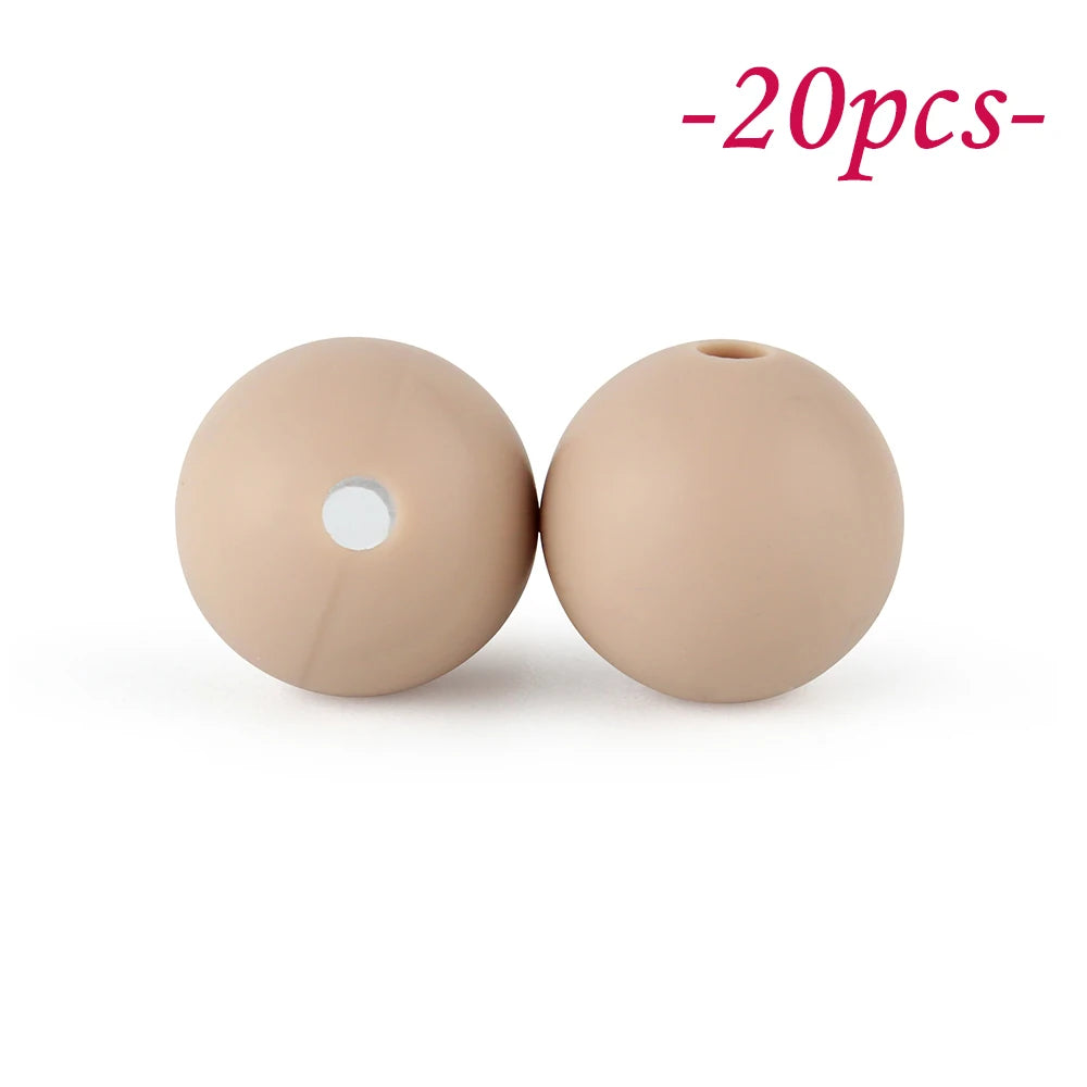 Two round, beige silicone beads are shown against a white background.
