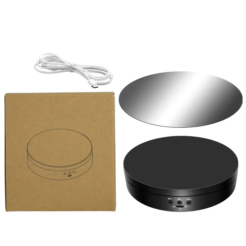 A motorized rotating display stand includes a mirror, a black base, and a power cord.