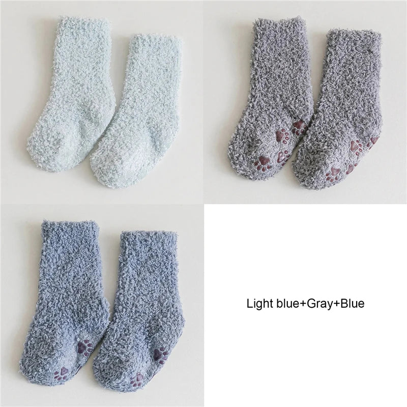 Three pairs of light blue and gray fleece socks with small blue accents