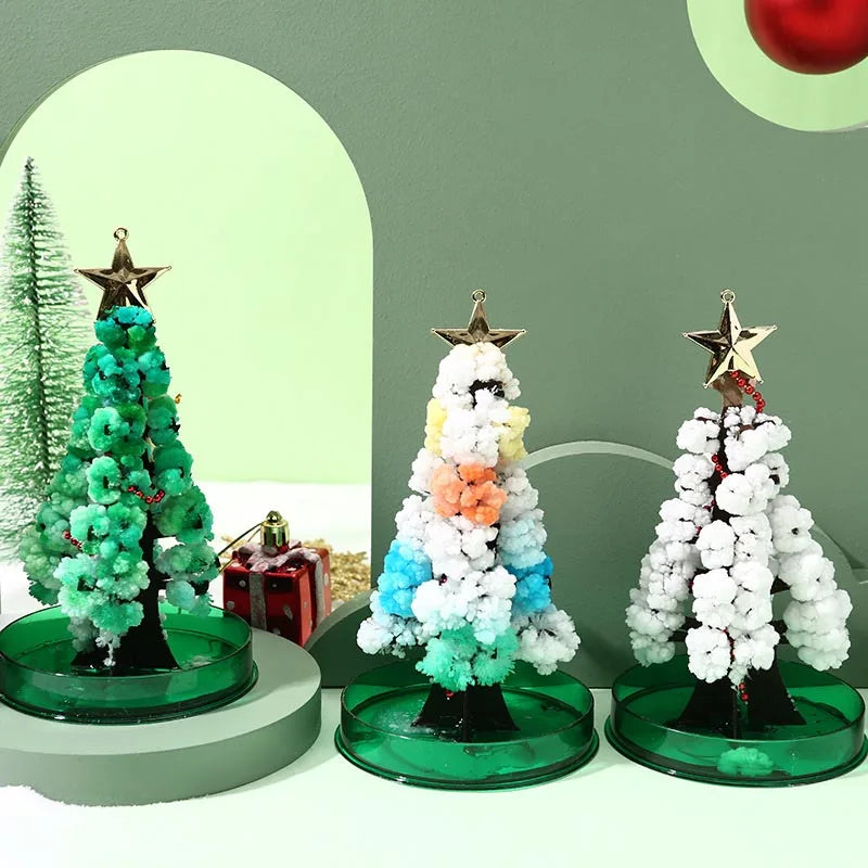 A set of crystal growing trees with star toppers displayed on a green and white background.