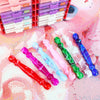 A collection of colorful diamond art pens with interchangeable tips displayed next to a red plastic storage box.