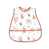 A white baby bib with a brown trim featuring various cartoon animal patterns like elephants and tigers.