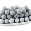 A pile of small, round gray silicone beads for jewelry making and DIY crafts.