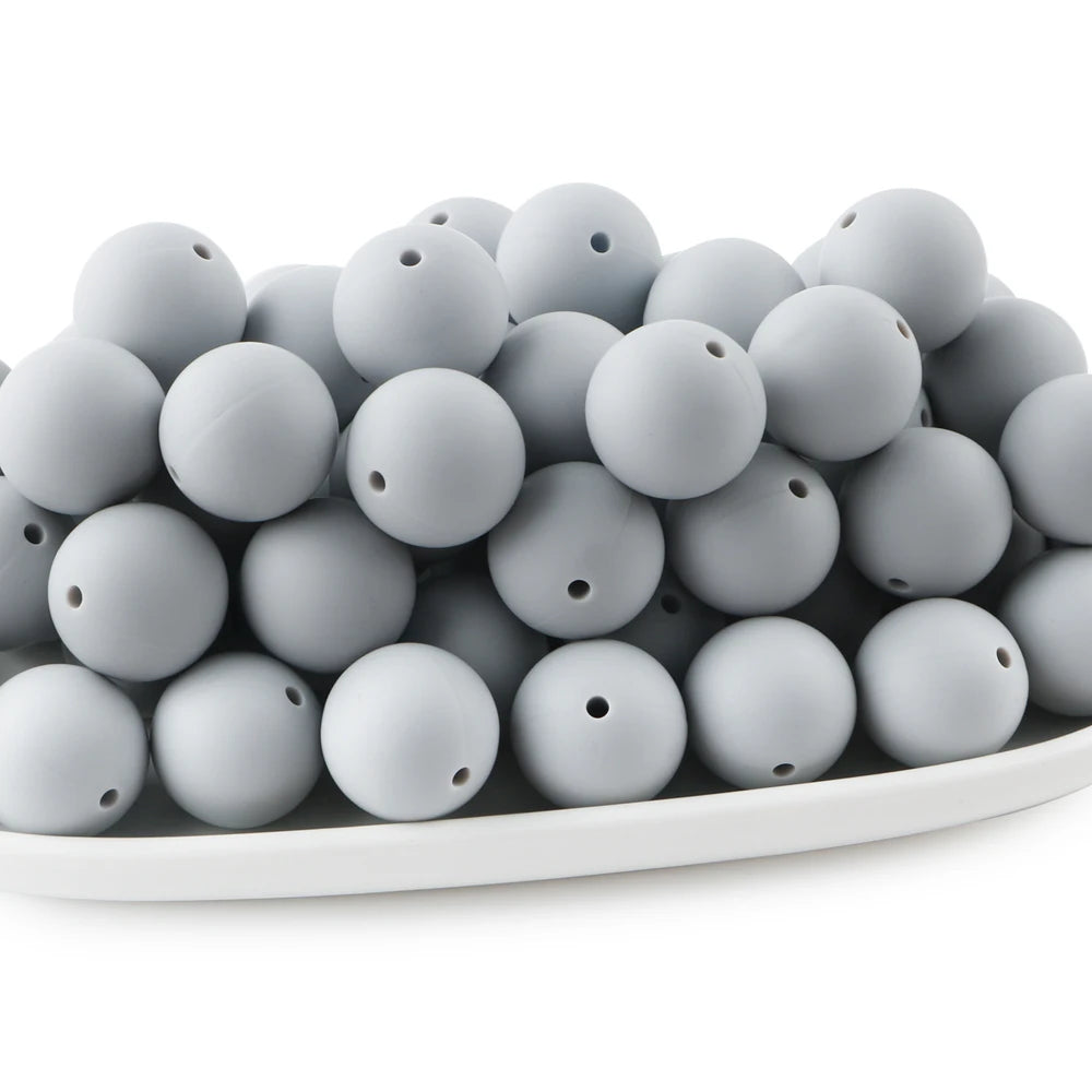 A pile of small, round gray silicone beads for jewelry making and DIY crafts.