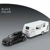 A black diecast model of an RV camper truck next to a white version, shown in a studio setting.