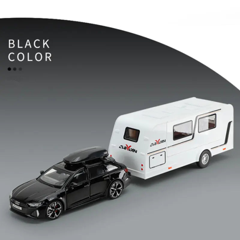A black diecast model of an RV camper truck next to a white version, shown in a studio setting.