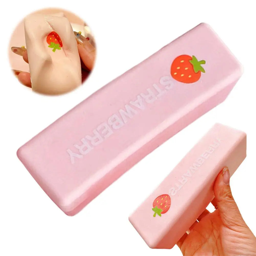 A pink strawberry milk squishy stress relief toy is shown in various angles, including a hand holding the product.