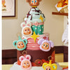 A tiered cake decorated with adorable animal-themed toppers and green and pink frosting.
