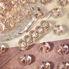 A collection of small, gold-traced pumpkin resin beads for jewelry making scattered on a surface.