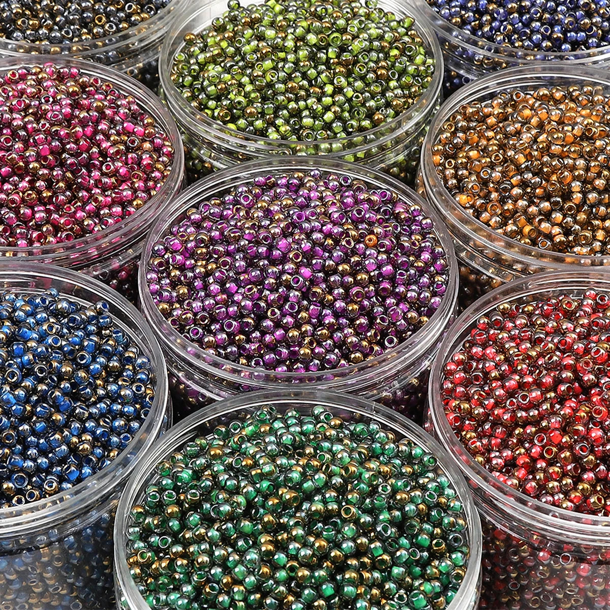 A collection of various colored glass beads in small clear containers for DIY jewelry making