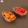 A miniature dollhouse vegetable basket play set filled with bright red and orange chili peppers.