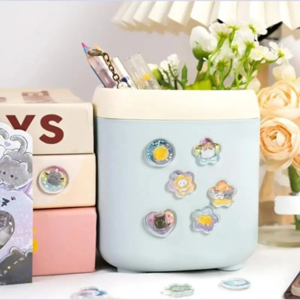A light blue ceramic container filled with heart-shaped crystal stickers and various craft supplies.