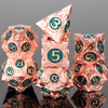 A set of seven pink metal dice, including a d20 and d12, are displayed on a reflective surface.
