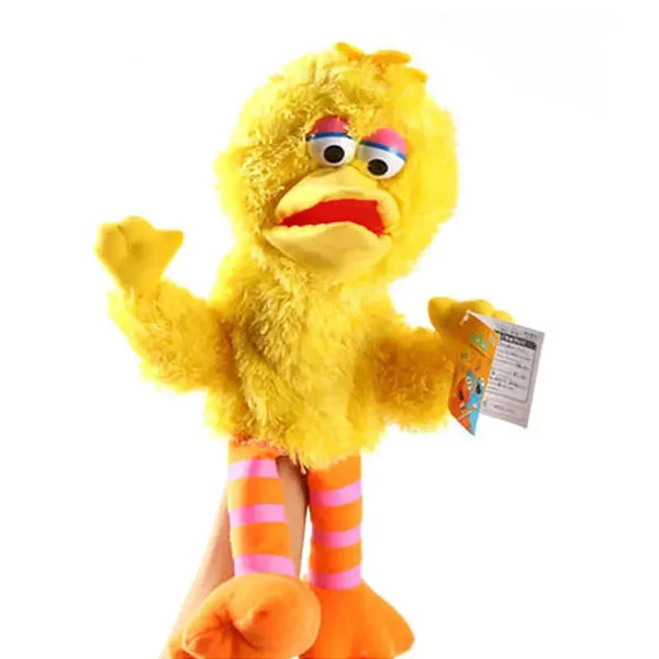 A yellow hand puppet plush toy resembling a bird with large eyes and orange striped legs.