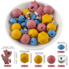 A variety of pink, yellow, and blue silicone beads shaped like cartoon animals are displayed in a white bowl with usage instr