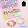 A clear plastic kit containing various colored polymer clay beads and a black beaded bracelet.