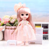 A pink articulated princess doll with long hair and a lace dress standing on a white surface.