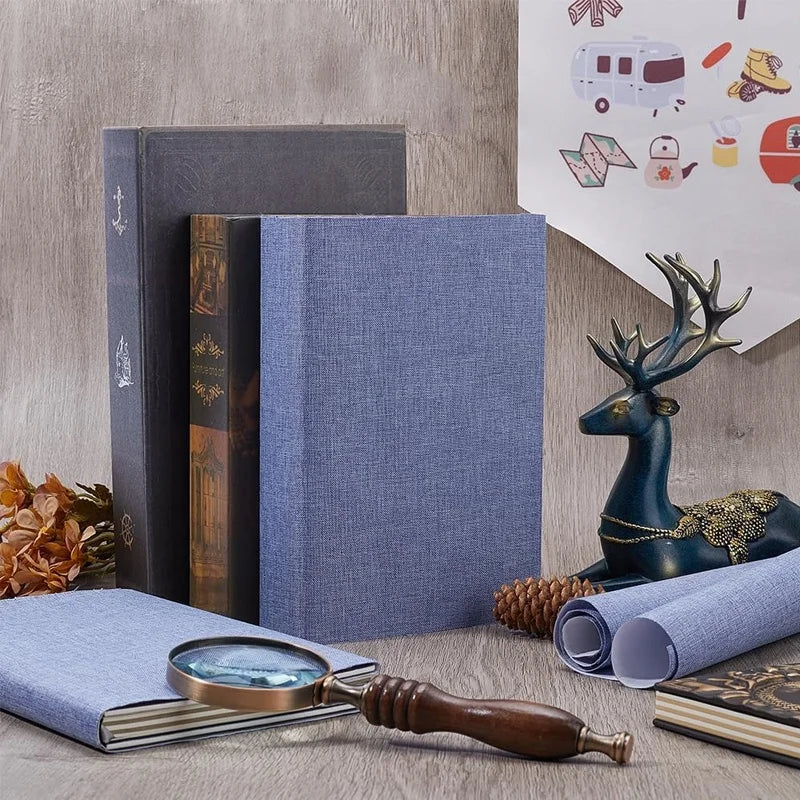A stack of linen book binding cloth is shown next to a wooden tool and a deer figurine.