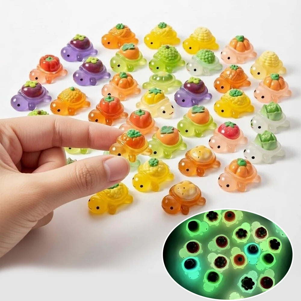 A hand holds a collection of mini glow-in-the-dark turtle resin figurines in various colors on a white surface.